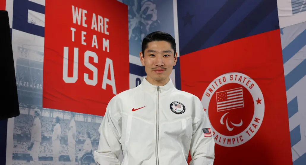 image of YanXiao Gong in front of a banner reading "We Are Team USA"