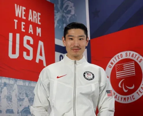 image of YanXiao Gong in front of a banner reading "We Are Team USA"
