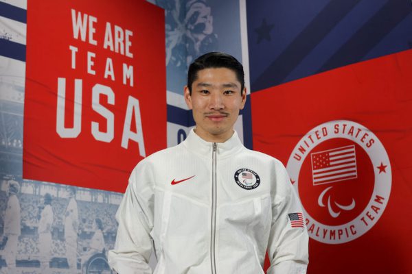 image of YanXiao Gong in front of a banner reading "We Are Team USA"