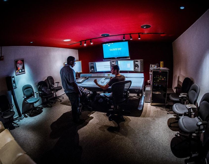 Two people conversing at a sound console