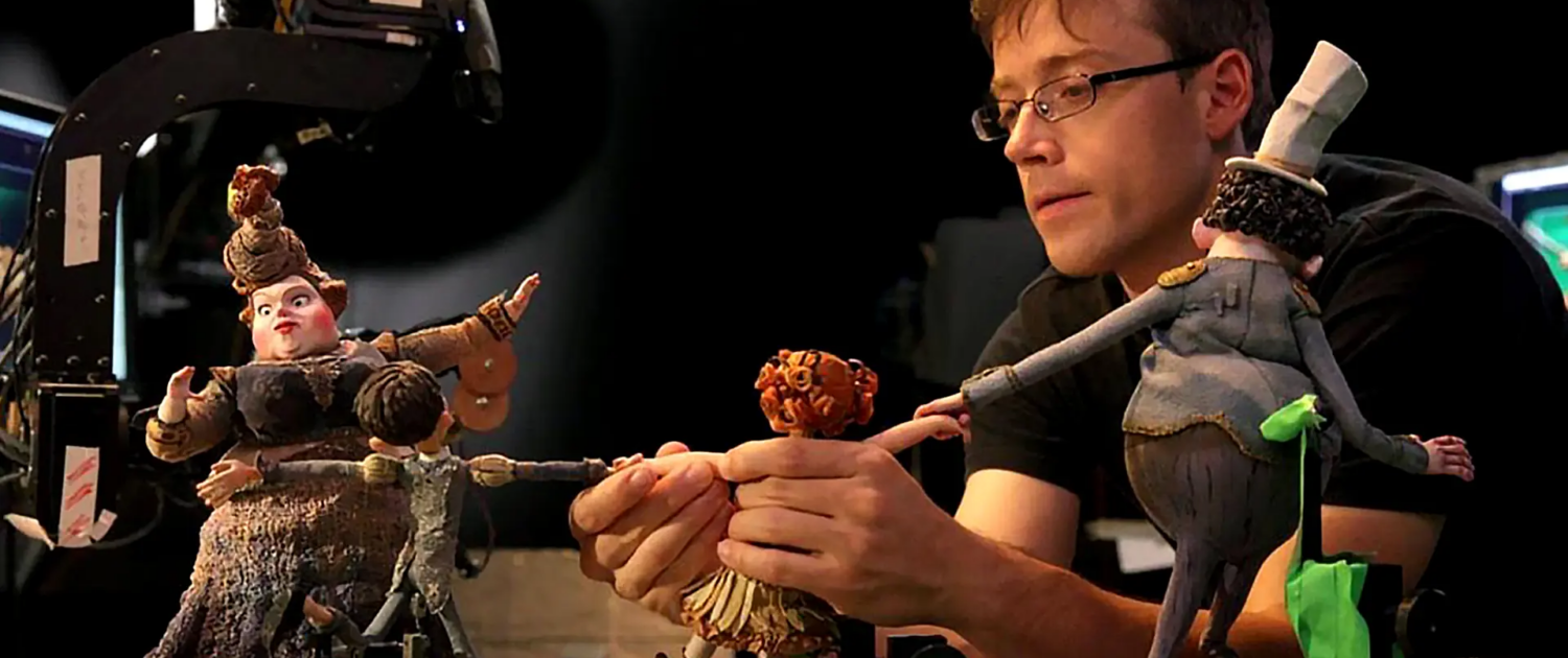 genres of animation explained; man setting up stop motion animation