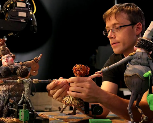 genres of animation explained; man setting up stop motion animation
