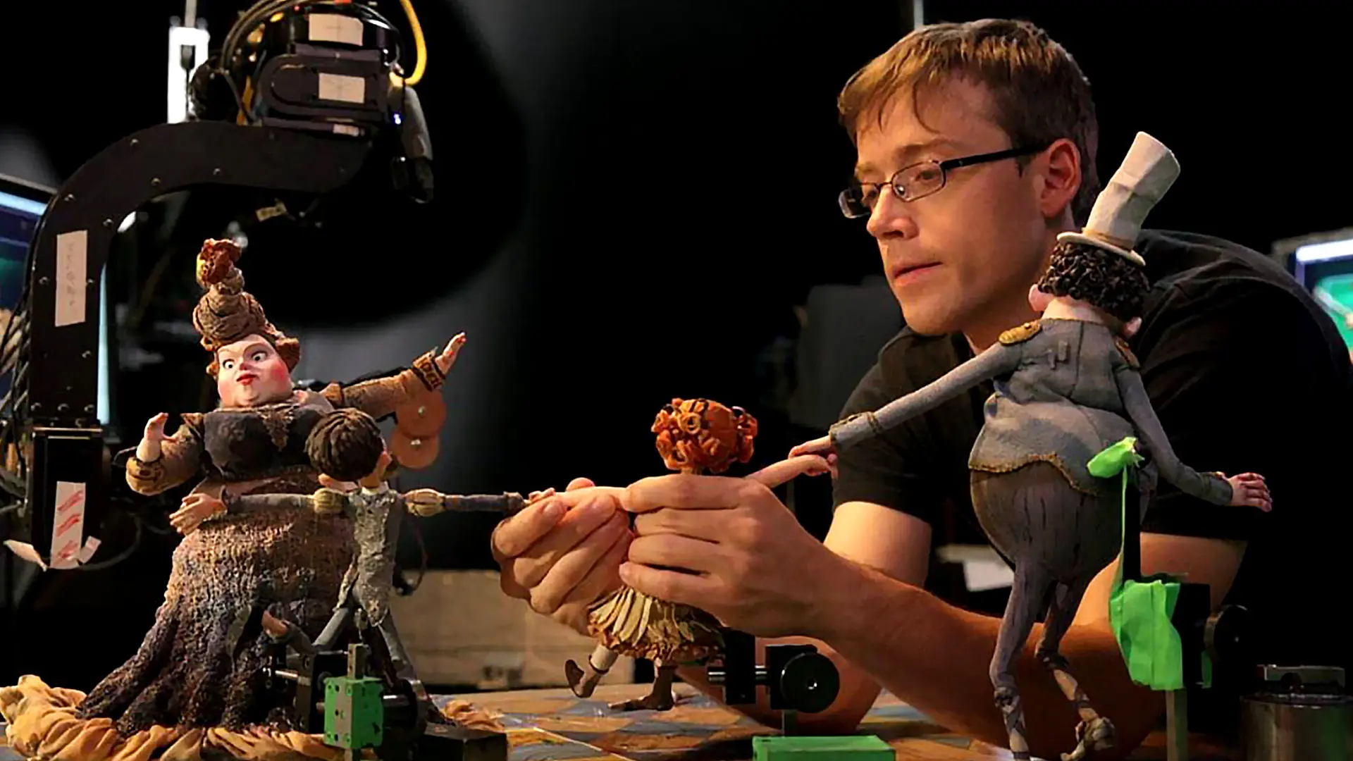 genres of animation explained; man setting up stop motion animation