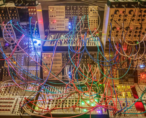 tangled wires all over a modular synth; women in electronic music